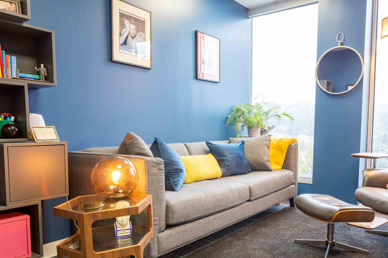 Blue psychology office with couch and comforting tools